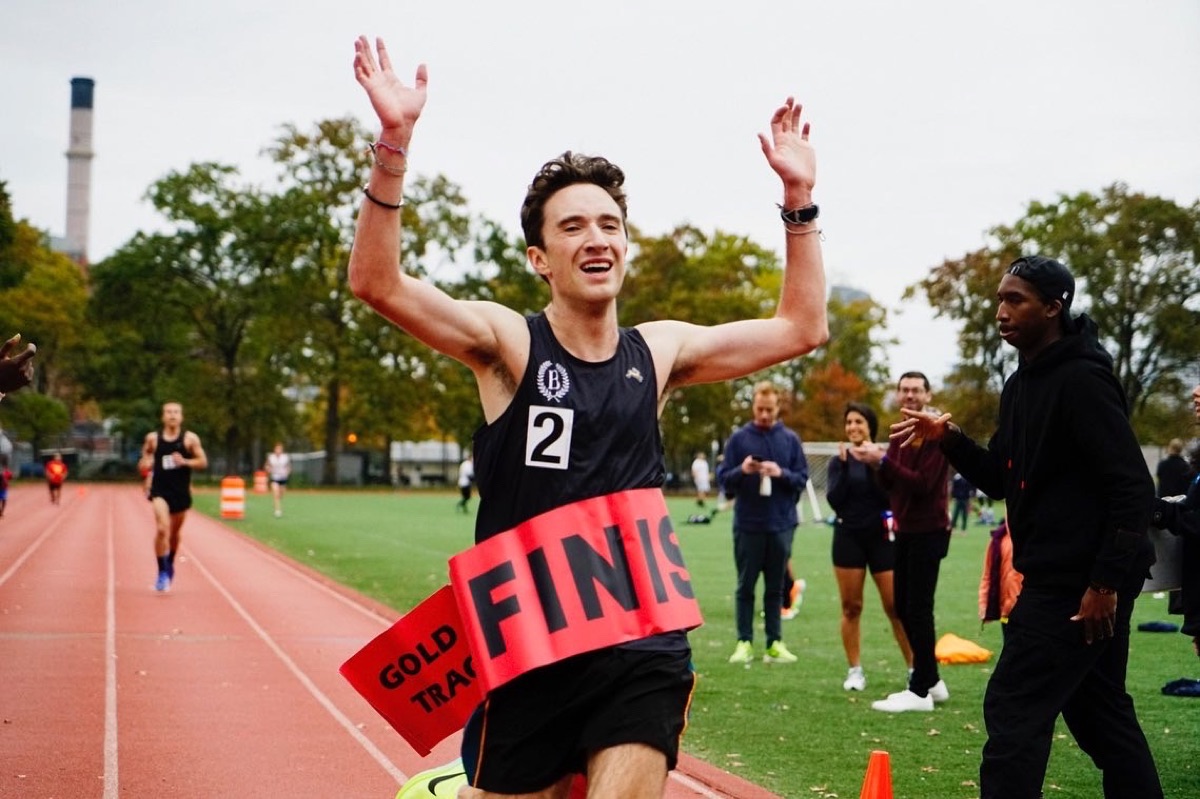 Crossing a race finish line with both arms raised