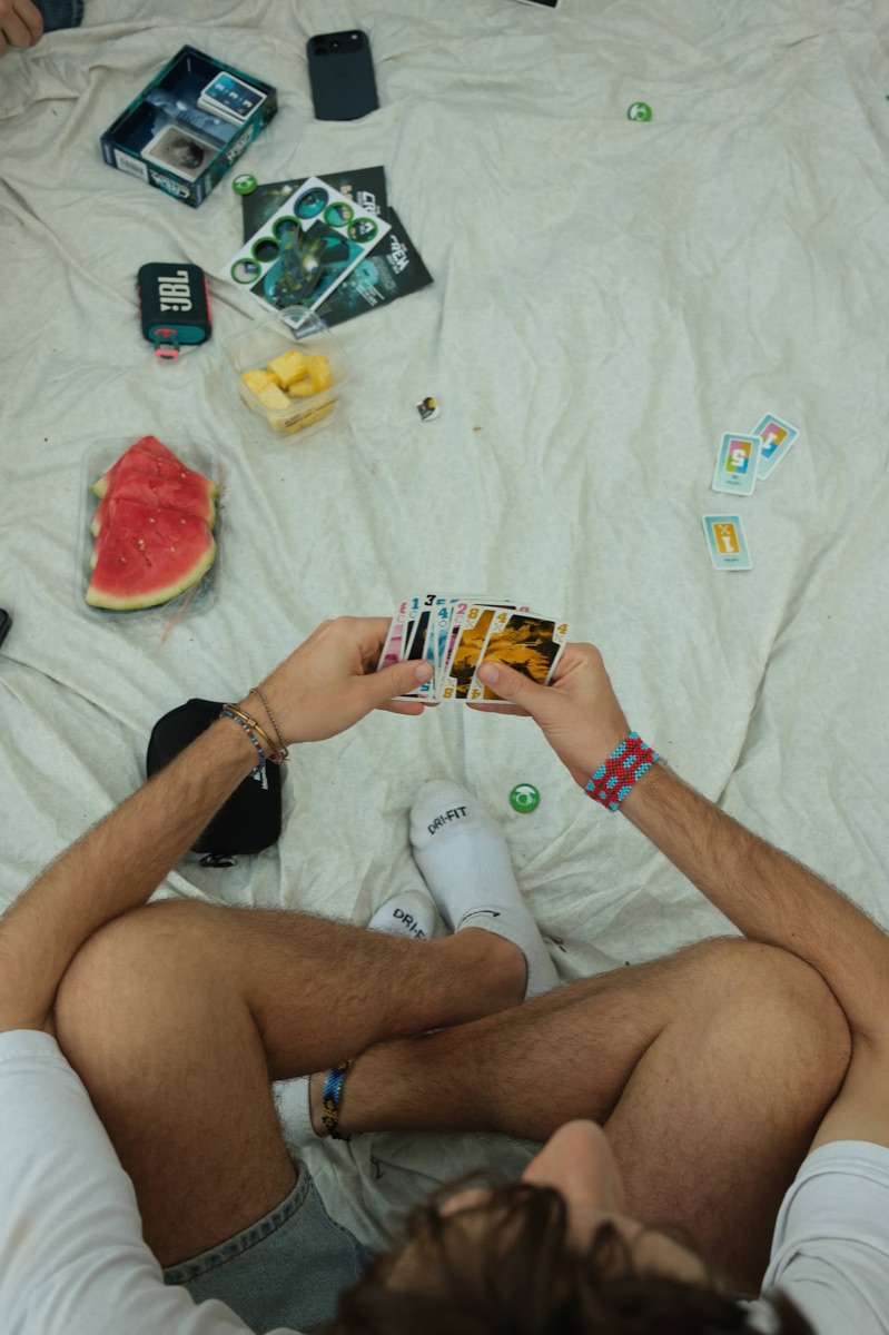 Watermelon and cards on a picnic blanket, from above