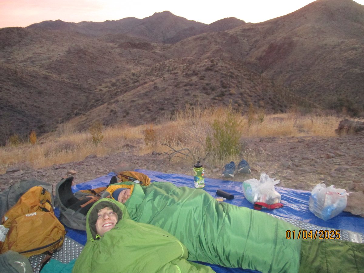 Waking up in sleeping bags on a desert ridge at dawn